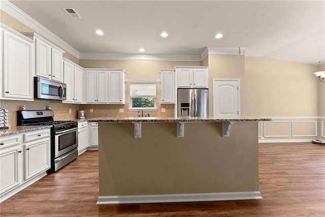 kitchen featuring appliances with stainless steel finishes, a kitchen island, and stone countertops