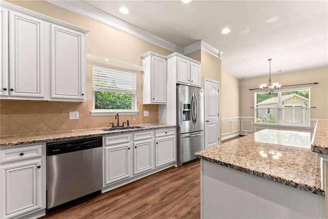 kitchen featuring appliances with stainless steel finishes, dark hardwood / wood-style floors, a wealth of natural light, sink, and white cabinets