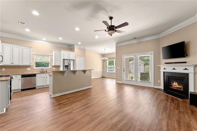 kitchen with plenty of natural light, light stone countertops, appliances with stainless steel finishes, and a center island