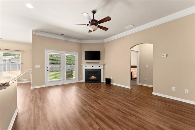 unfurnished living room with ceiling fan, dark hardwood / wood-style floors, and ornamental molding