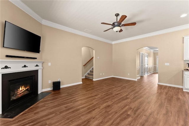 unfurnished living room featuring hardwood / wood-style flooring, ceiling fan, and crown molding