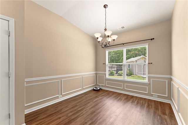 empty room with lofted ceiling, an inviting chandelier, and dark hardwood / wood-style floors