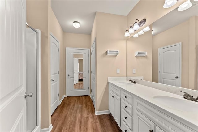 bathroom with hardwood / wood-style flooring, vanity, and an enclosed shower