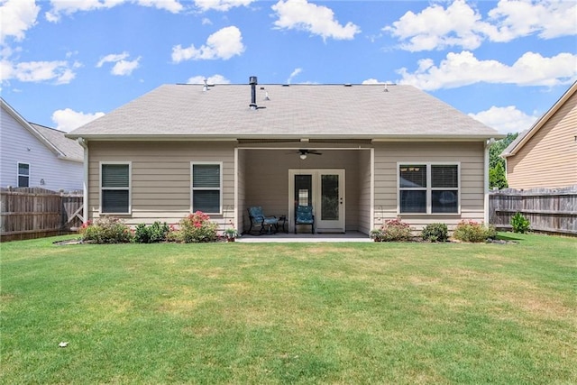 rear view of house with ceiling fan, a patio, and a yard