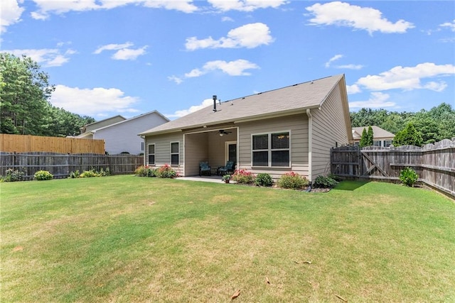 rear view of property featuring a lawn, ceiling fan, and a patio area