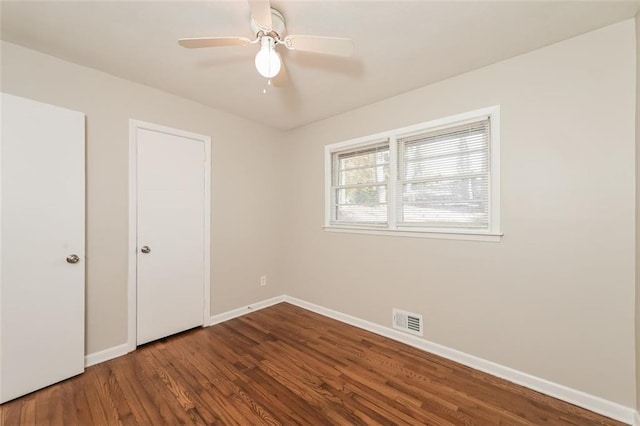 unfurnished bedroom with visible vents, a ceiling fan, baseboards, and wood finished floors