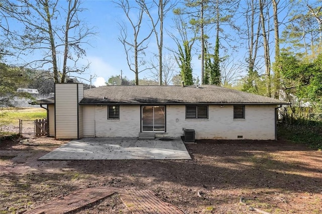 rear view of house with a patio, cooling unit, crawl space, brick siding, and a chimney