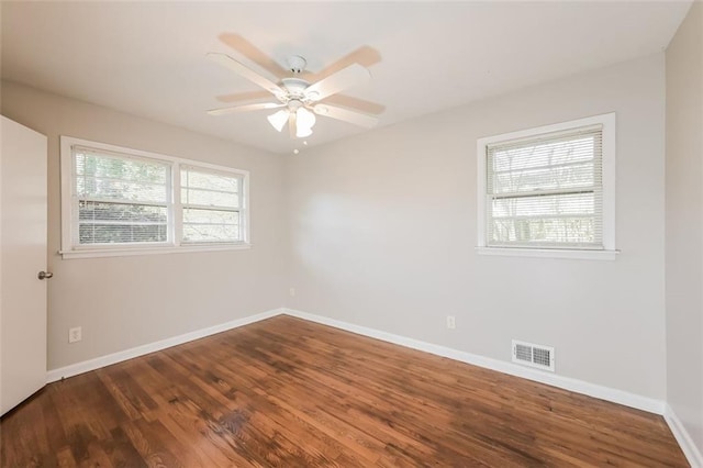 unfurnished room with ceiling fan, visible vents, baseboards, and wood finished floors