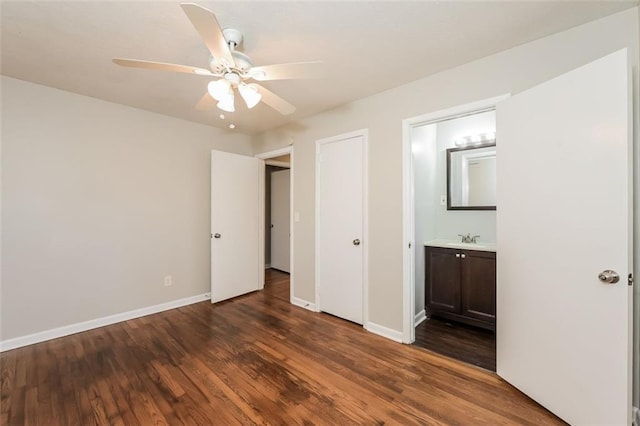 unfurnished bedroom with a sink, baseboards, and wood finished floors