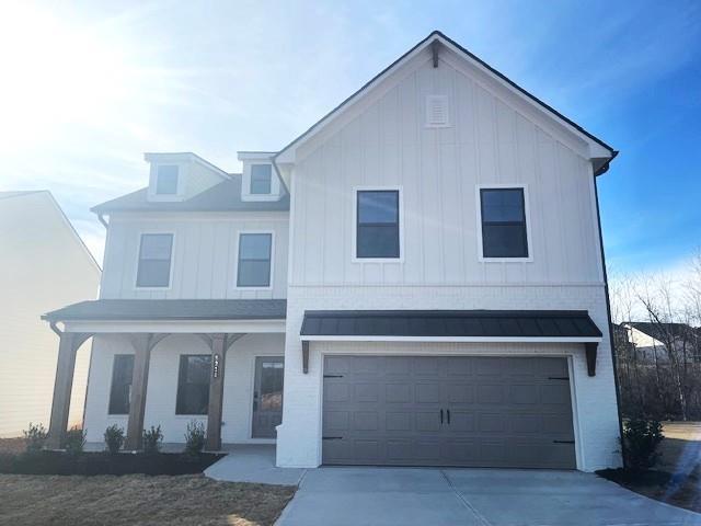 view of front of house with a garage, a front yard, and a porch