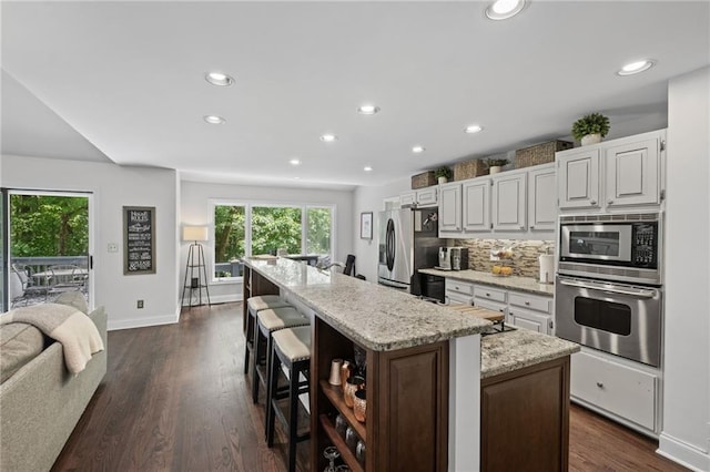 3648 Sope Creek Farm SE, Marietta, GA 30067 - kitchen with stainless steel appliances, plenty of natural light, an island with sink, recessed lighting, and a breakfast bar area