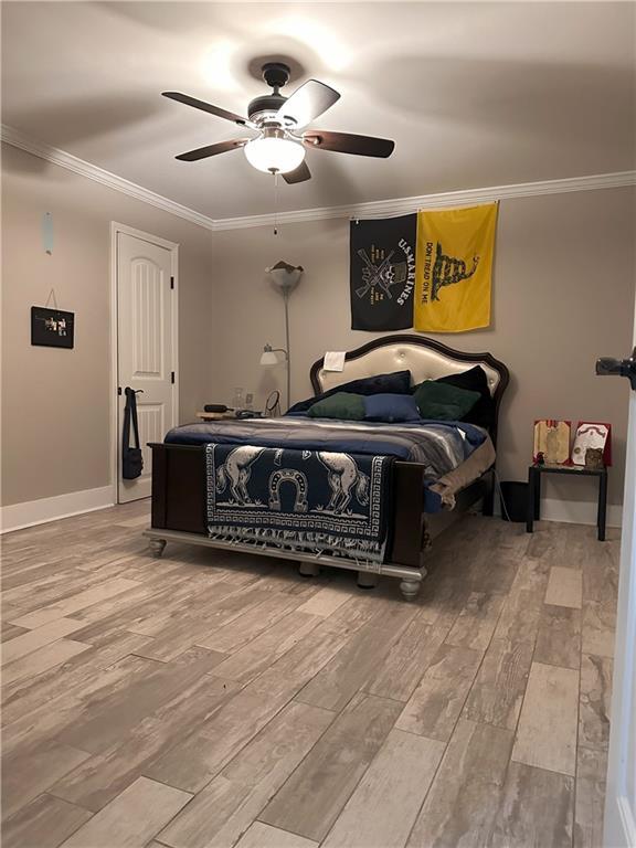 1055 Worthington Hills Dr, Roswell, GA 30076 - bedroom with wood finished floors, ornamental molding, a ceiling fan, and baseboards