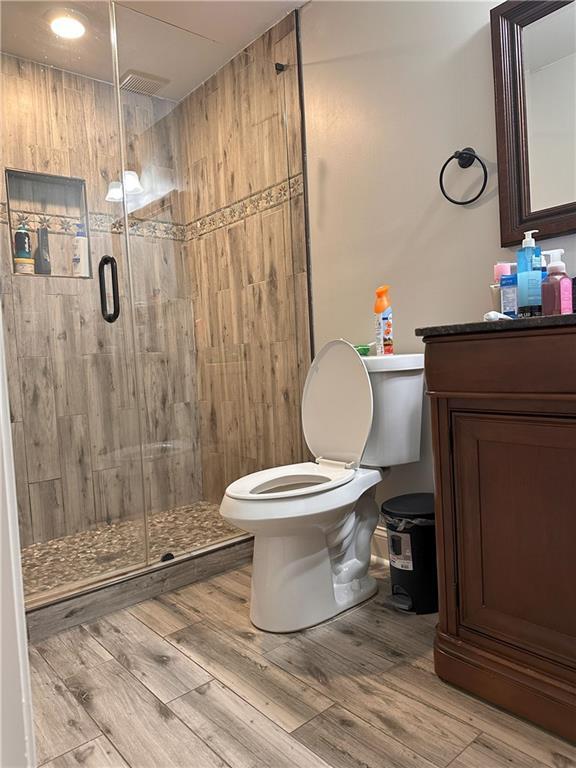 1055 Worthington Hills Dr, Roswell, GA 30076 - full bath featuring toilet, vanity, a shower stall, and wood finished floors