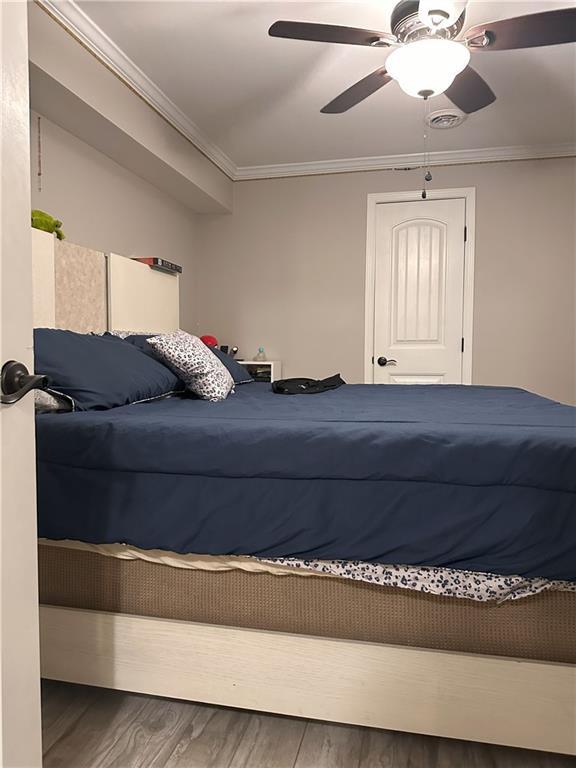1055 Worthington Hills Dr, Roswell, GA 30076 - bedroom with wood finished floors, ornamental molding, and a ceiling fan