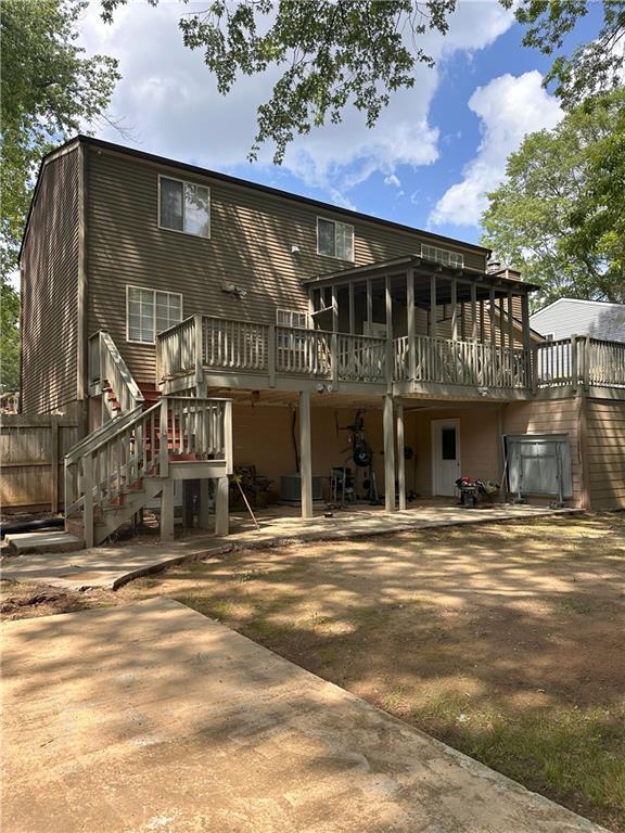 1055 Worthington Hills Dr, Roswell, GA 30076 - rear view of property featuring a wooden deck, stairs, and a patio area