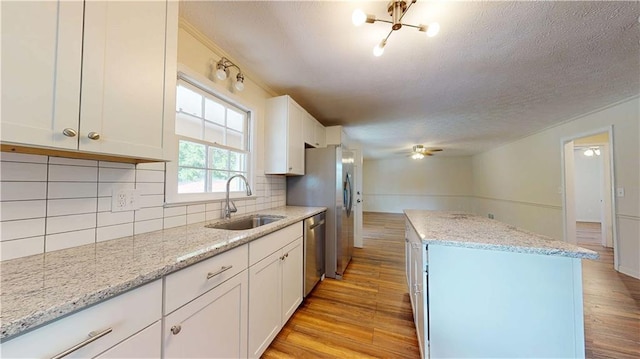 25 Forrest Ln, Cartersville, GA 30121 - kitchen featuring a center island, appliances with stainless steel finishes, a textured ceiling, white cabinetry, and light wood finished floors