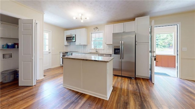 25 Forrest Ln, Cartersville, GA 30121 - kitchen with stainless steel appliances, a kitchen island, wood finished floors, white cabinets, and a textured ceiling