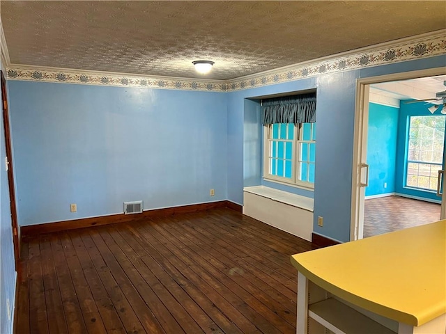 spare room featuring ceiling fan, ornamental molding, dark hardwood / wood-style floors, and a textured ceiling