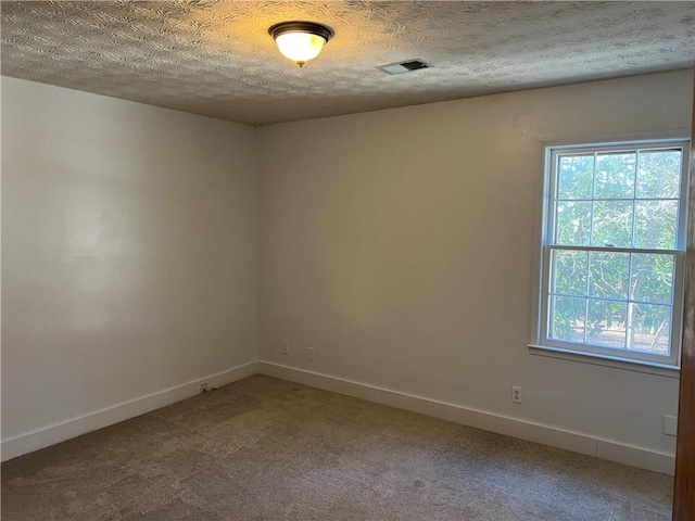 unfurnished room featuring carpet flooring and a textured ceiling