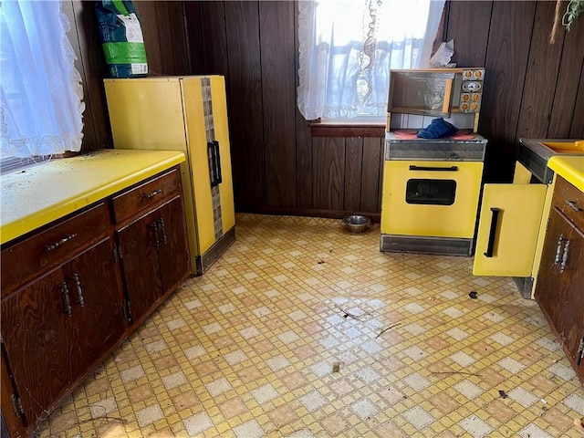 kitchen with refrigerator and wood walls