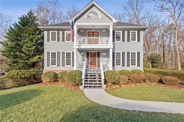 view of front facade with covered porch, a balcony, and a front lawn