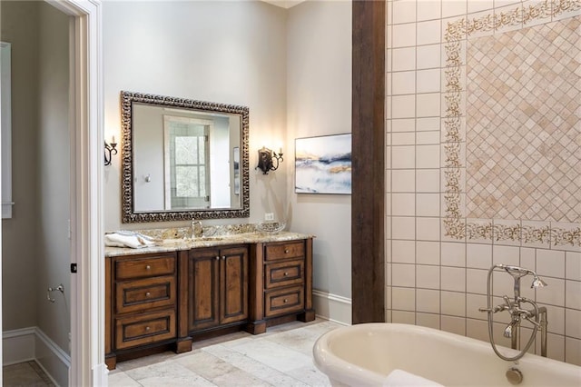 full bathroom with a freestanding bath, vanity, and baseboards