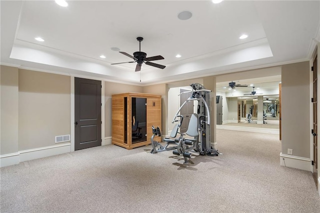 workout area featuring light carpet, a raised ceiling, visible vents, and recessed lighting