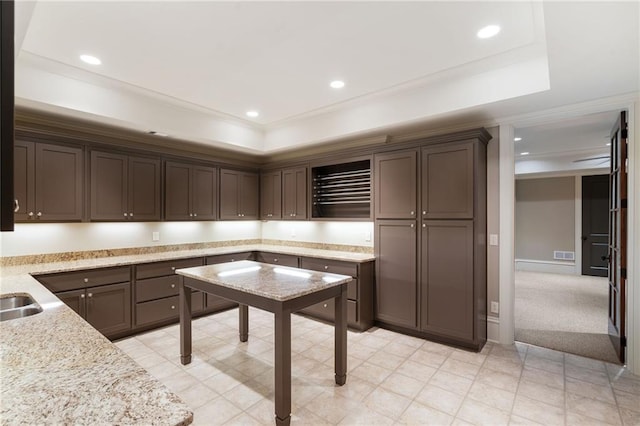 kitchen with recessed lighting, a raised ceiling, and visible vents