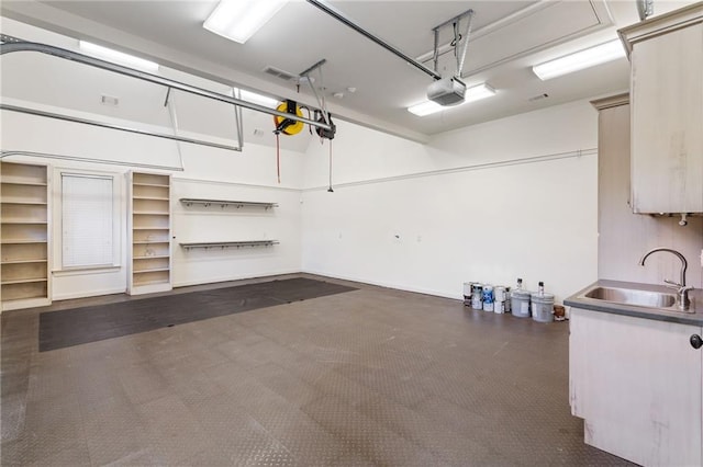 garage with a garage door opener and a sink