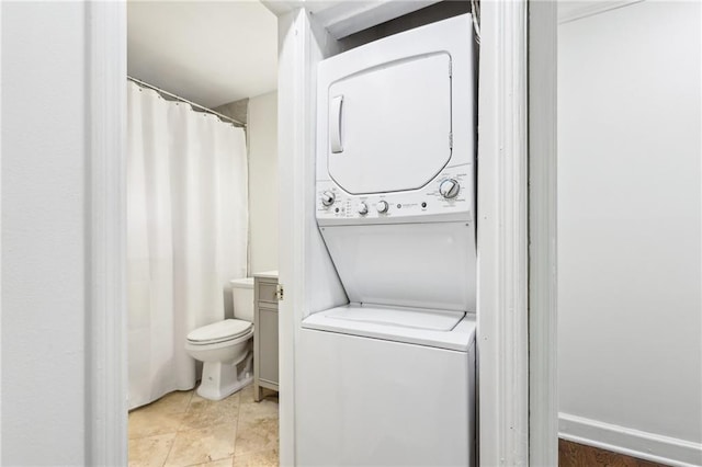 clothes washing area featuring laundry area and stacked washing maching and dryer