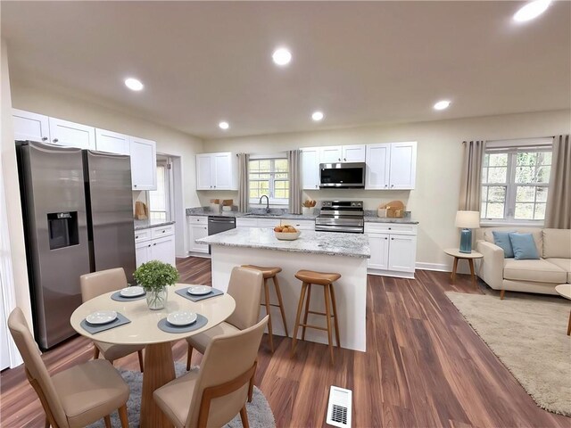 2182 Rosewood Rd, Decatur, GA 30032 - kitchen featuring white cabinets, visible vents, a sink, a center island, and appliances with stainless steel finishes