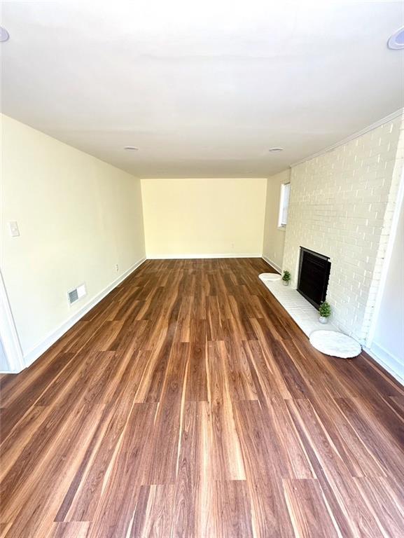 2182 Rosewood Rd, Decatur, GA 30032 - below grade area with baseboards, wood finished floors, visible vents, and a fireplace