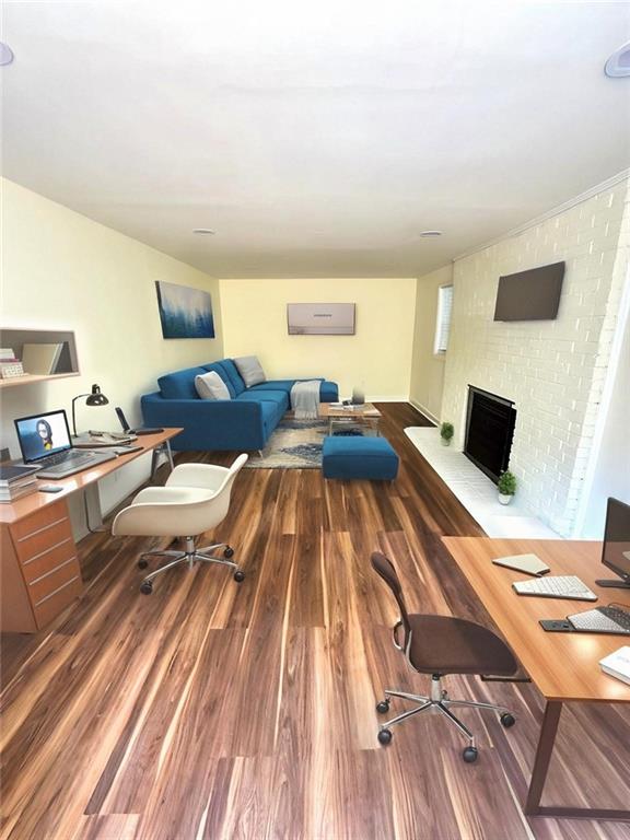 2182 Rosewood Rd, Decatur, GA 30032 - living room featuring a brick fireplace, wood finished floors, and a wall unit AC