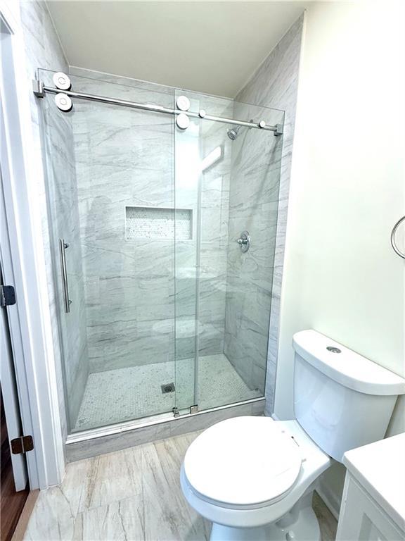 2182 Rosewood Rd, Decatur, GA 30032 - bathroom featuring vanity, toilet, and a stall shower