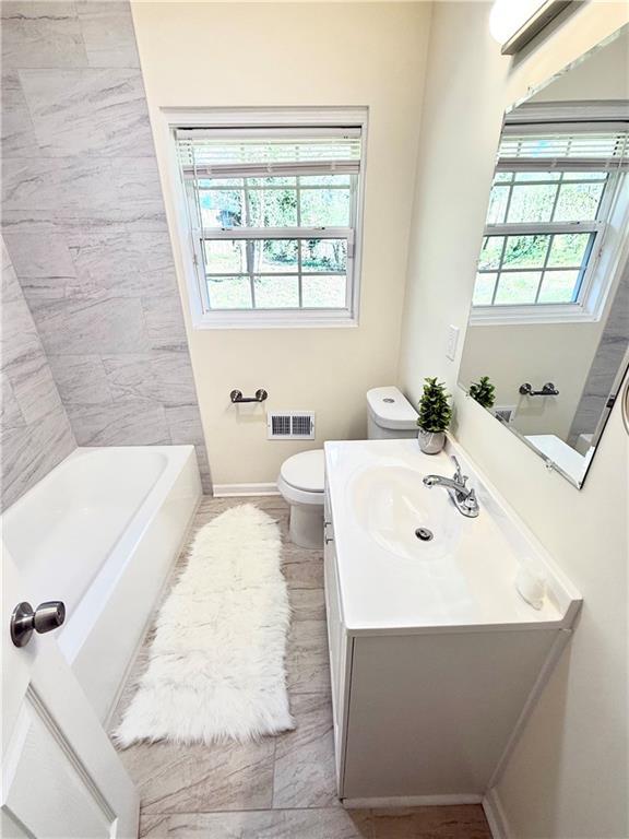 2182 Rosewood Rd, Decatur, GA 30032 - full bath with baseboards, visible vents, vanity, and toilet