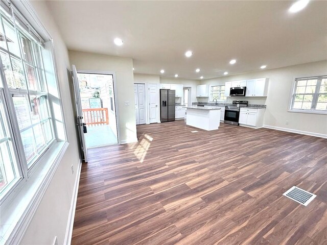 2182 Rosewood Rd, Decatur, GA 30032 - kitchen with dark wood-style floors, visible vents, a kitchen island, baseboards, and appliances with stainless steel finishes