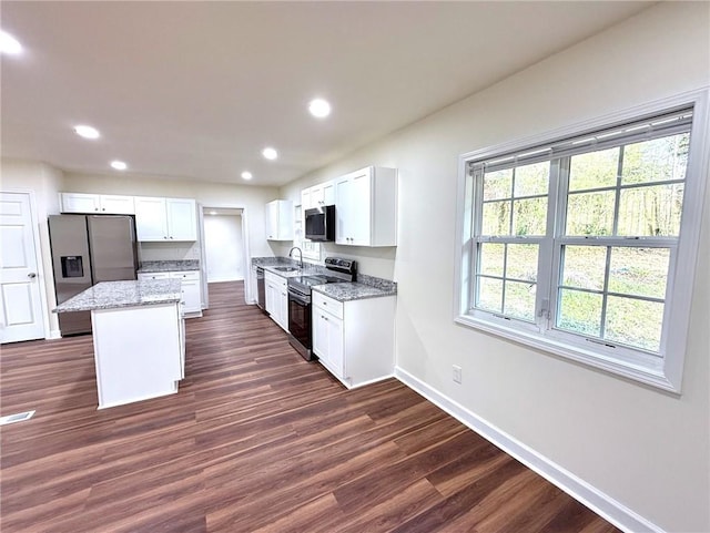 2182 Rosewood Rd, Decatur, GA 30032 - kitchen featuring light stone counters, stainless steel appliances, a sink, a kitchen island, and baseboards