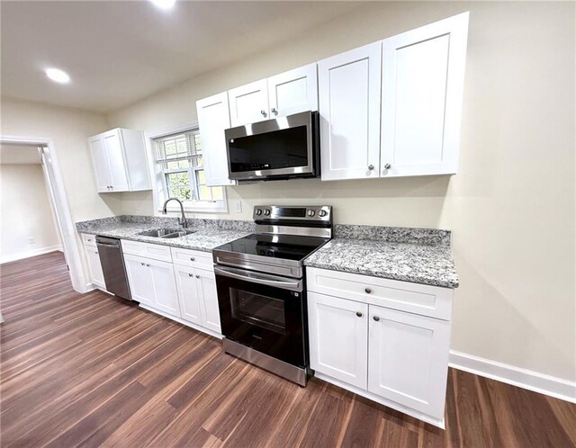 2182 Rosewood Rd, Decatur, GA 30032 - kitchen with white cabinets, stainless steel appliances, a sink, baseboards, and dark wood-style flooring