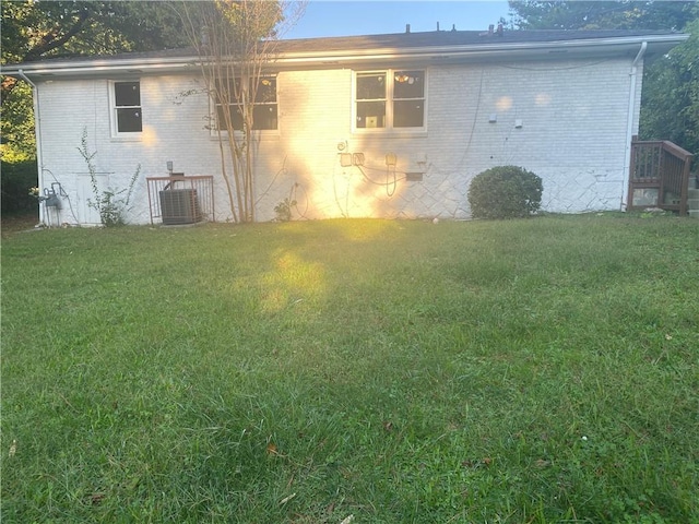 view of property exterior featuring central AC unit and a lawn