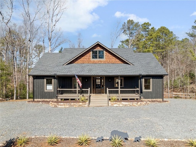 view of front of house with a porch, driveway, and roof with shingles