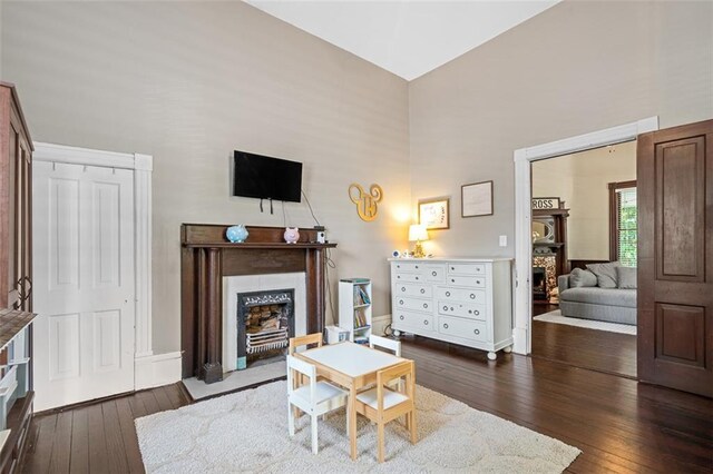 161 N Barton St, Norcross, GA 30071 - living area with a fireplace with flush hearth, dark wood-style flooring, a high ceiling, and baseboards