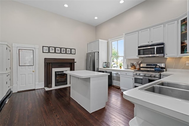 161 N Barton St, Norcross, GA 30071 - kitchen with appliances with stainless steel finishes, a center island, dark wood-style floors, a fireplace with flush hearth, and recessed lighting