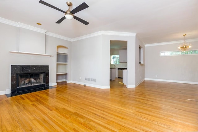 unfurnished living room featuring light wood-type flooring, a healthy amount of sunlight, and a tiled fireplace