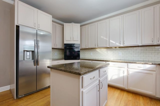 kitchen with stainless steel refrigerator with ice dispenser, dark stone countertops, oven, white cabinets, and a center island