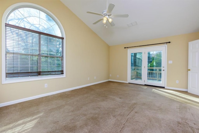 carpeted spare room with ceiling fan and high vaulted ceiling