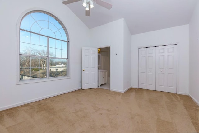 unfurnished bedroom featuring ceiling fan, a closet, light carpet, and high vaulted ceiling