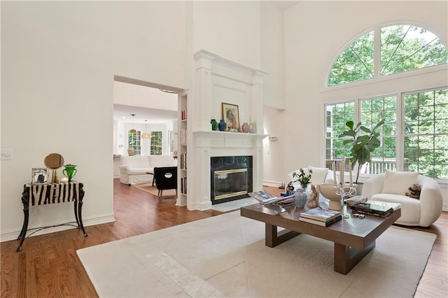 12160 Oak Hollow Way, Alpharetta, GA 30005 - living area featuring a towering ceiling, wood finished floors, and a fireplace