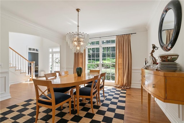 12160 Oak Hollow Way, Alpharetta, GA 30005 - dining space with a decorative wall, a chandelier, light wood finished floors, crown molding, and stairs