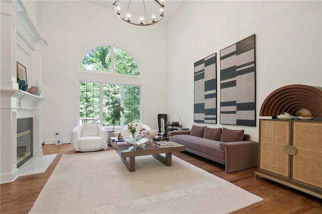 12160 Oak Hollow Way, Alpharetta, GA 30005 - living room with a towering ceiling, wood finished floors, a chandelier, and a glass covered fireplace