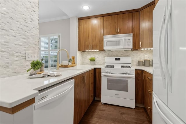 812 Dixie Ave NE, Atlanta, GA 30307 - kitchen featuring white appliances, brown cabinets, dark wood-style flooring, decorative backsplash, and recessed lighting